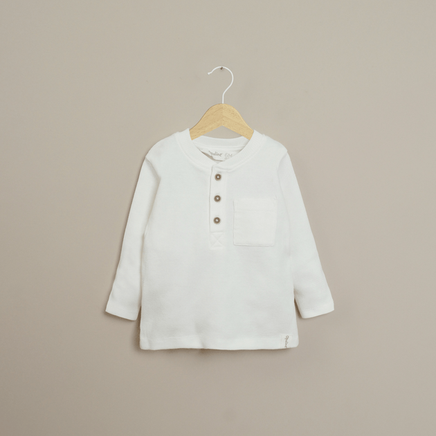 Polera blanca de niño con bolsillo en el pecho